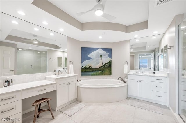 bathroom featuring vanity, a tray ceiling, shower with separate bathtub, and ceiling fan