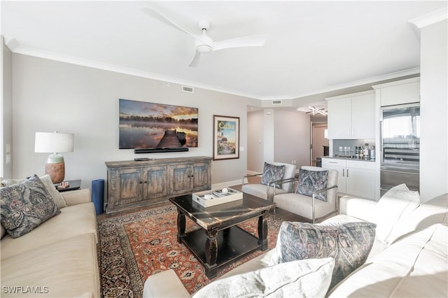 living room featuring ceiling fan and ornamental molding