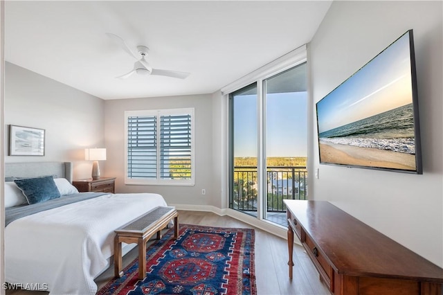 bedroom featuring multiple windows, access to exterior, ceiling fan, and light hardwood / wood-style flooring