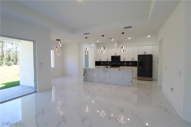 kitchen featuring black appliances, pendant lighting, white cabinetry, and a tray ceiling