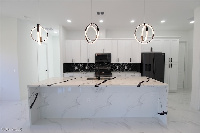 kitchen with white cabinetry, light stone counters, decorative light fixtures, and appliances with stainless steel finishes