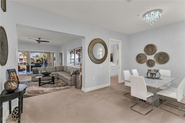 dining space featuring ceiling fan with notable chandelier and light colored carpet