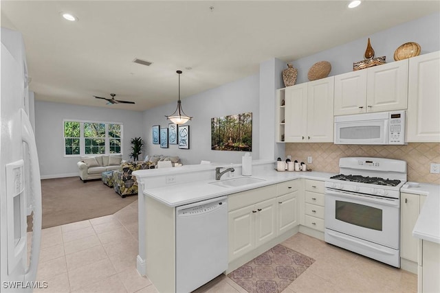 kitchen featuring sink, white appliances, kitchen peninsula, and hanging light fixtures