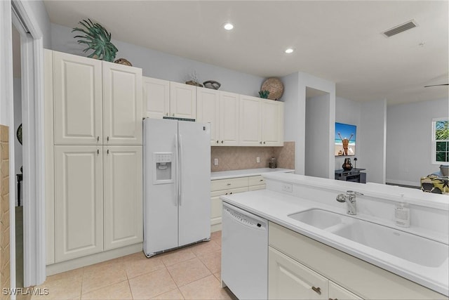 kitchen featuring white appliances, white cabinetry, light tile patterned floors, decorative backsplash, and sink