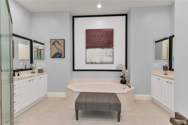 bathroom with a bathing tub, tile patterned flooring, and vanity