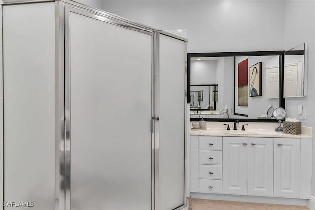 bathroom with vanity and a shower with door