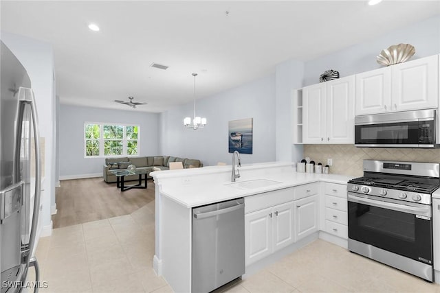 9219 Corfu Ct Unit 202, Naples, FL 34114 - kitchen with stainless steel appliances, open floor plan, a peninsula, recessed lighting, and white cabinets