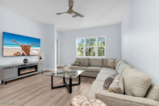 9219 Corfu Ct Unit 202, Naples, FL 34114 - living room with light wood finished floors, a ceiling fan, and a glass covered fireplace