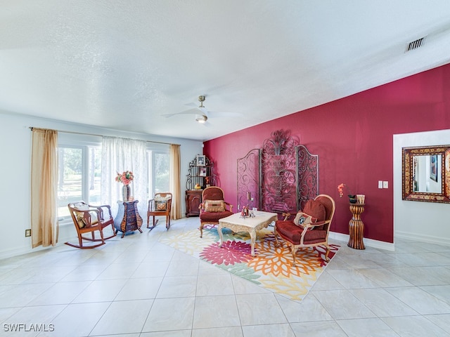 sitting room with ceiling fan, light tile patterned flooring, and a textured ceiling