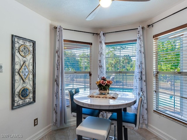 dining space with plenty of natural light, ceiling fan, light tile patterned floors, and a textured ceiling