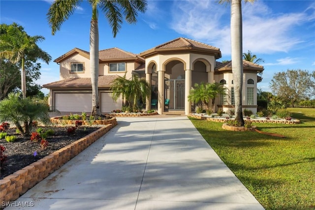 mediterranean / spanish-style house featuring a garage and a front lawn