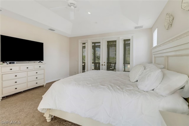 carpeted bedroom with ceiling fan, a raised ceiling, access to outside, and french doors