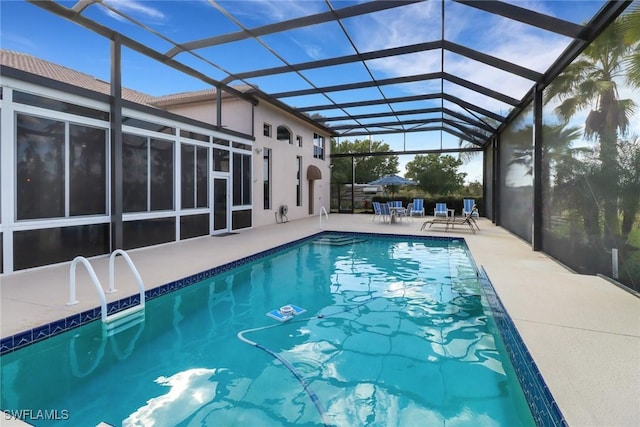 view of swimming pool with glass enclosure and a patio