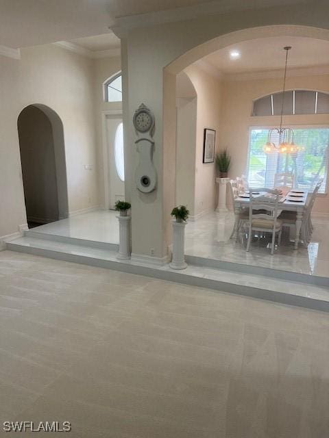 entryway featuring crown molding and a chandelier