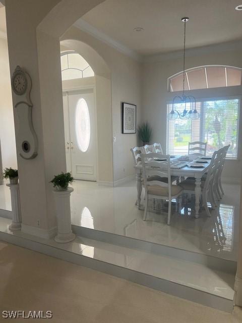 dining area with ornamental molding and a chandelier