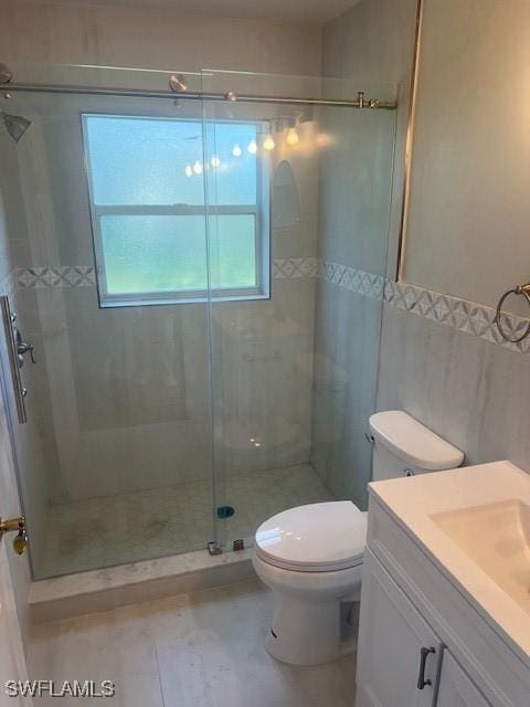 bathroom featuring tile patterned floors, vanity, an enclosed shower, and toilet