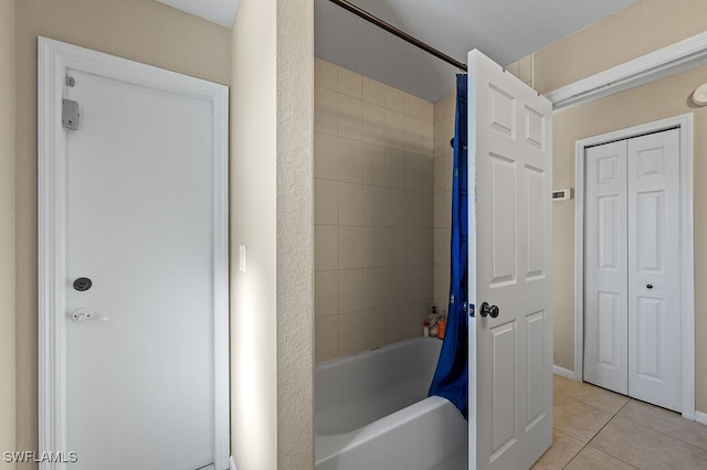 bathroom featuring tile patterned flooring and tiled shower / bath