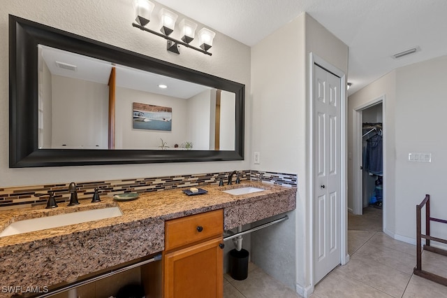 bathroom featuring tasteful backsplash, tile patterned flooring, and vanity