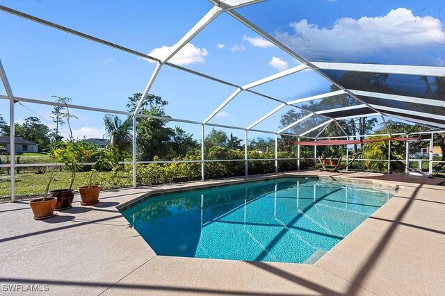 view of swimming pool featuring a lanai and a patio