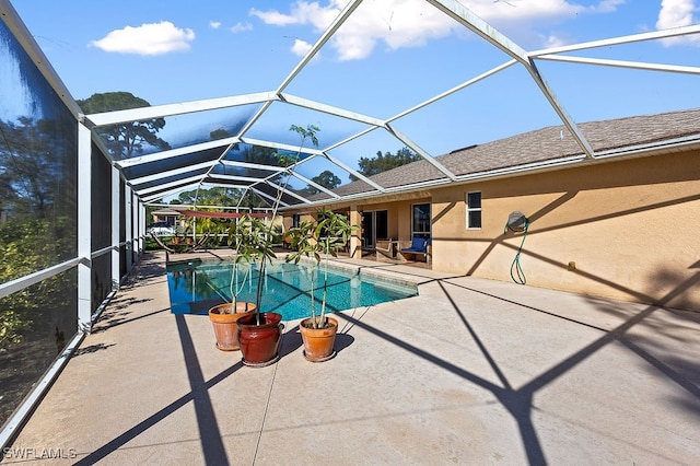 view of pool with glass enclosure and a patio