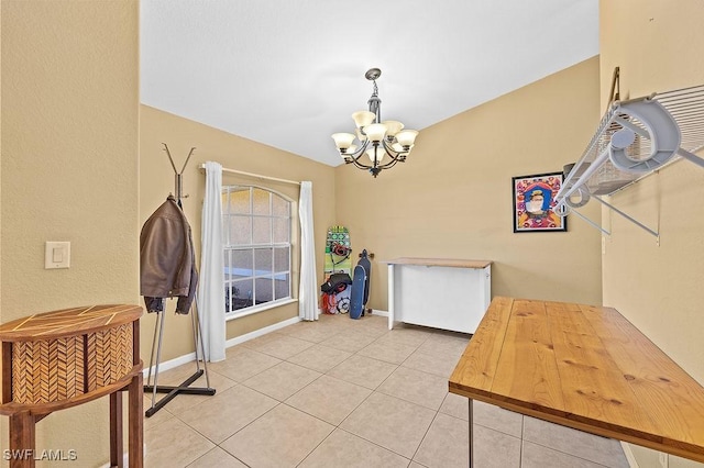 dining space with baseboards, a notable chandelier, and light tile patterned flooring