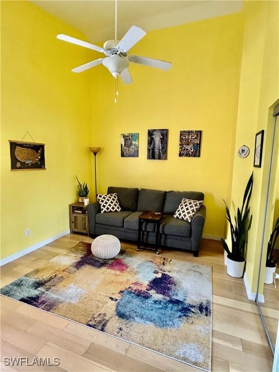 living room with hardwood / wood-style flooring and ceiling fan