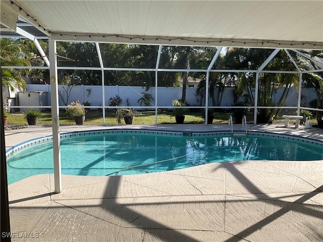 view of swimming pool featuring a lanai and a patio area