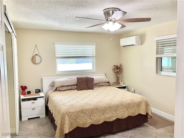 tiled bedroom with ceiling fan, a wall mounted air conditioner, and a textured ceiling