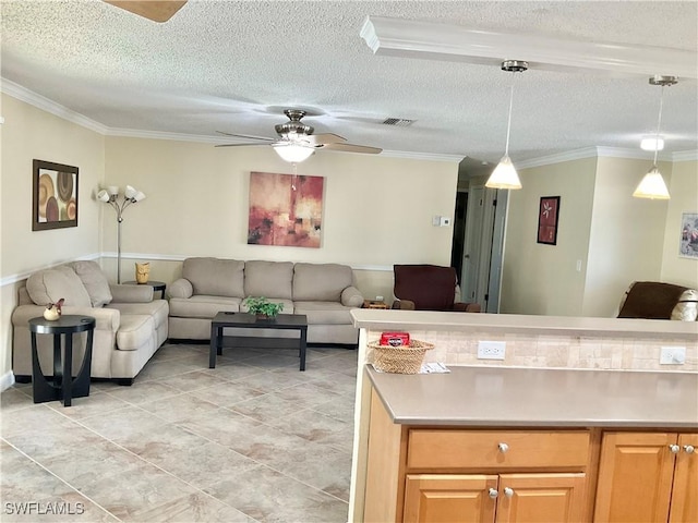 kitchen with pendant lighting, ceiling fan, crown molding, and a textured ceiling