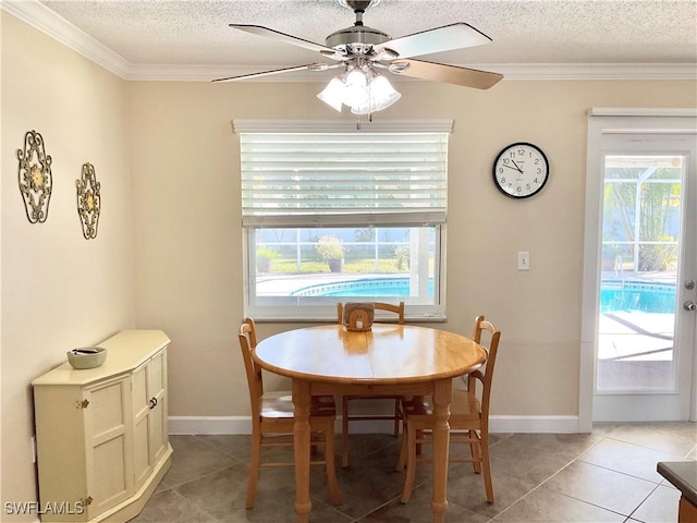 tiled dining area featuring crown molding, a textured ceiling, and a wealth of natural light