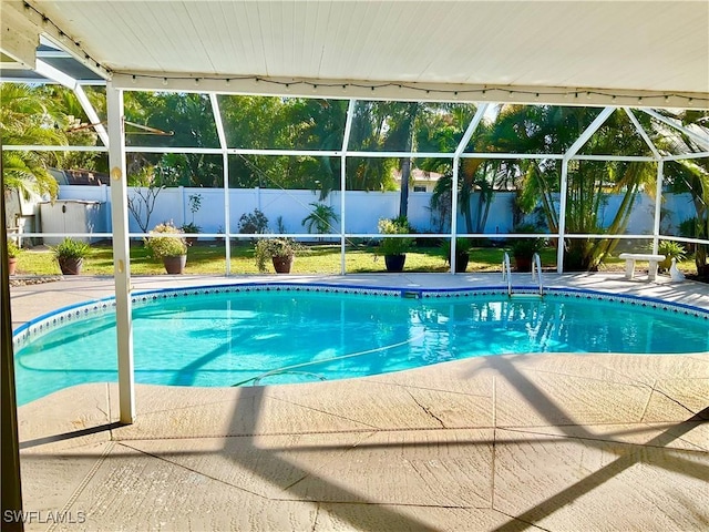 view of swimming pool featuring a patio and a lanai