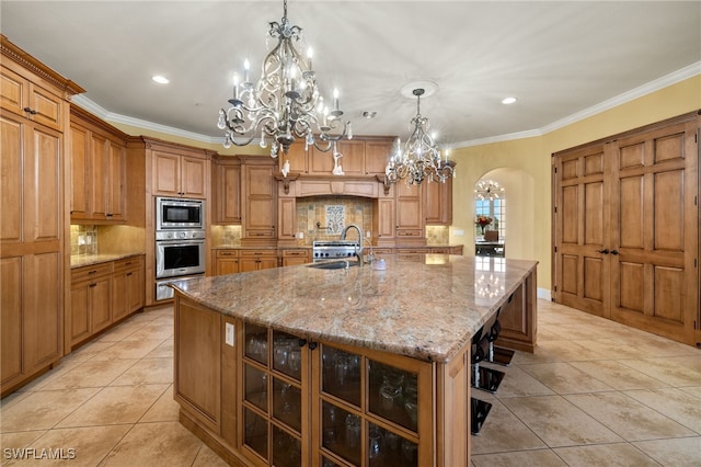 kitchen with pendant lighting, a spacious island, sink, ornamental molding, and appliances with stainless steel finishes