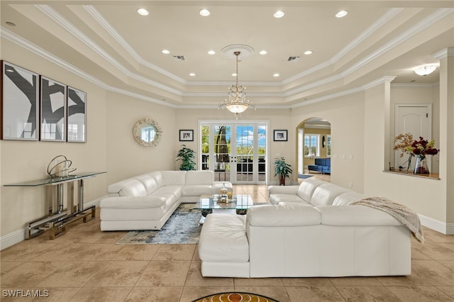 living room featuring a raised ceiling, french doors, an inviting chandelier, and ornamental molding