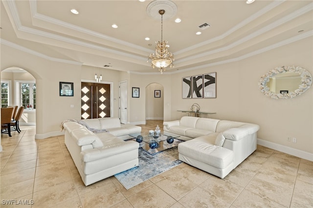 living room with a raised ceiling, an inviting chandelier, light tile patterned floors, and ornamental molding