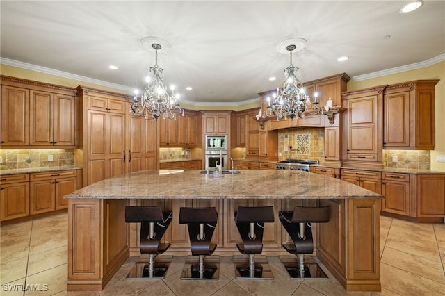 kitchen featuring a notable chandelier, a kitchen bar, and a large island with sink