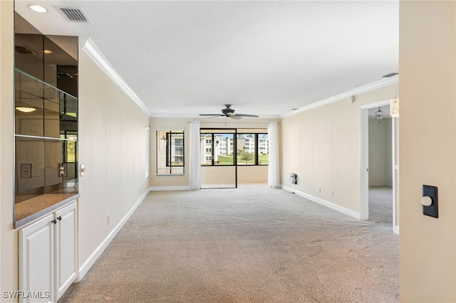 unfurnished room with light carpet, ceiling fan, and crown molding