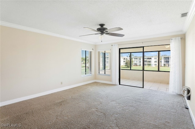 carpeted spare room featuring a textured ceiling, ceiling fan, and crown molding