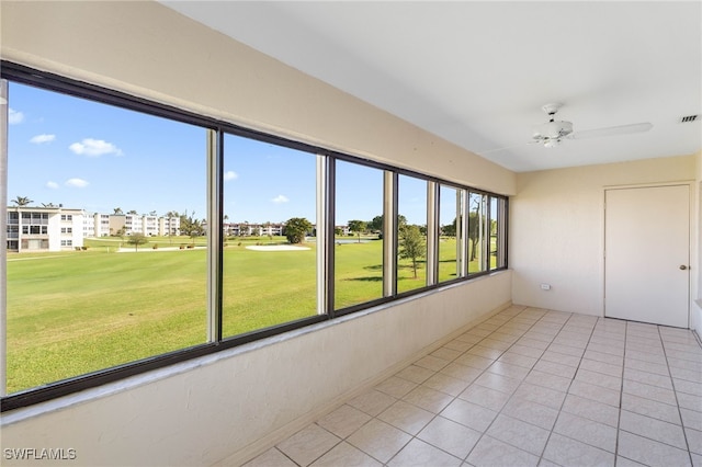 unfurnished sunroom featuring a wealth of natural light and ceiling fan