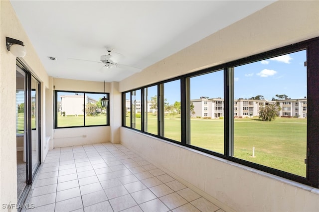 unfurnished sunroom featuring ceiling fan