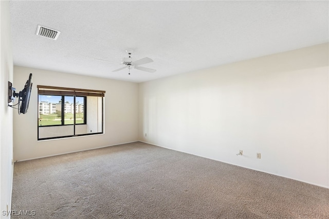 spare room featuring carpet flooring, a textured ceiling, and ceiling fan