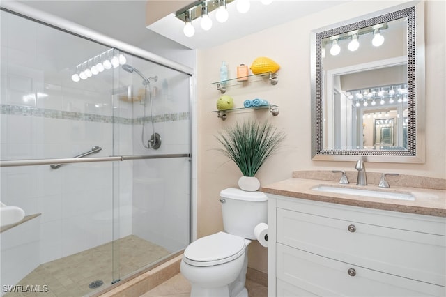 bathroom with tile patterned floors, vanity, toilet, and walk in shower