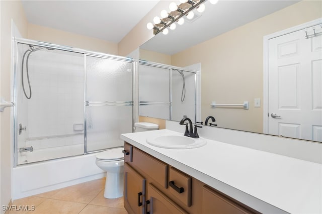 full bathroom with tile patterned flooring, vanity, enclosed tub / shower combo, and toilet