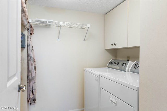 clothes washing area featuring cabinets, independent washer and dryer, and a textured ceiling