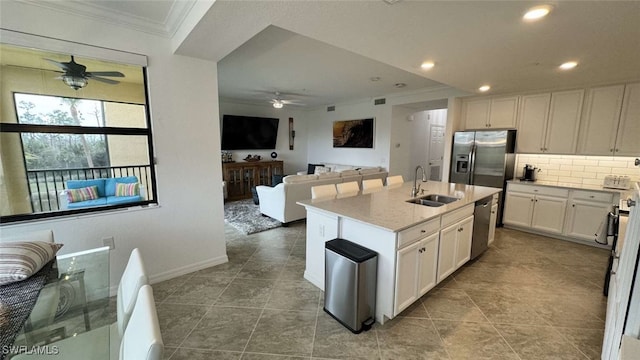 kitchen featuring sink, stainless steel appliances, crown molding, a kitchen island with sink, and white cabinets