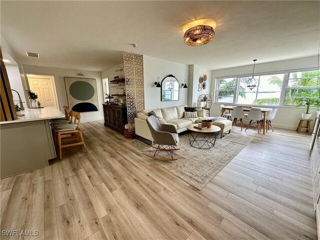 1900 Clifford St Unit 201, Fort Myers, FL 33901 - living area with light wood finished floors, baseboards, and a chandelier