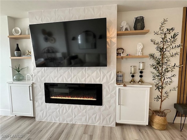 interior details with a tile fireplace and wood-type flooring