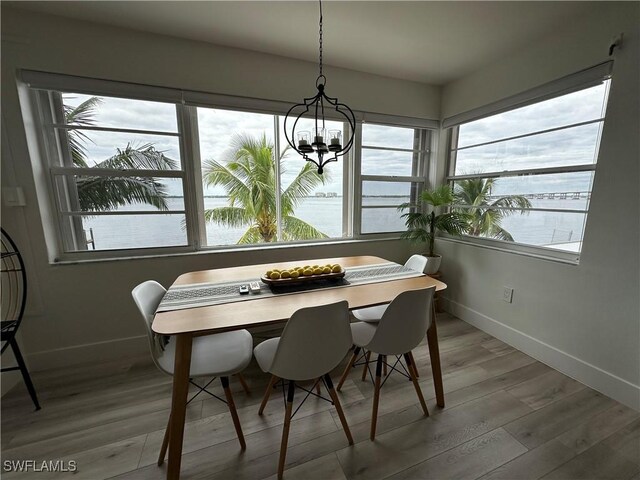 1900 Clifford St Unit 201, Fort Myers, FL 33901 - dining room with baseboards, wood finished floors, a chandelier, and a water view