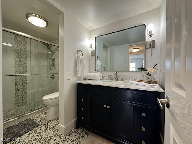 bathroom with tile patterned flooring, vanity, a shower with shower door, and toilet