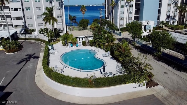 view of swimming pool with a patio area and a water view