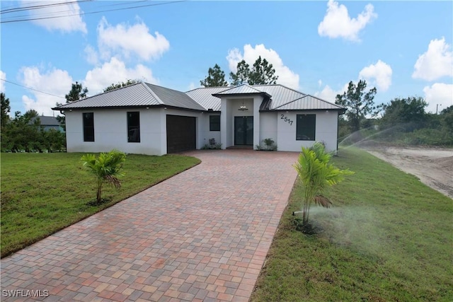 2517 11th St SW, Lehigh Acres, FL 33976 - view of front of home featuring stucco siding, decorative driveway, and metal roof
